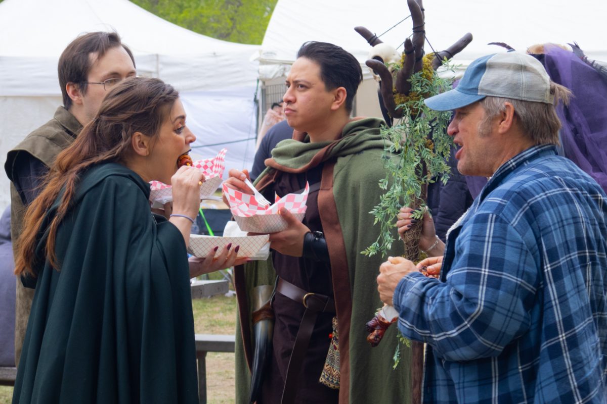 A group of friends eat festival food on April 20 at the Great Plains Renaissance Festival.