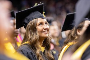 A graduate smiles while listening to the opening remarks on May 11. Wichita State hosted three commencement ceremonies throughout the day.