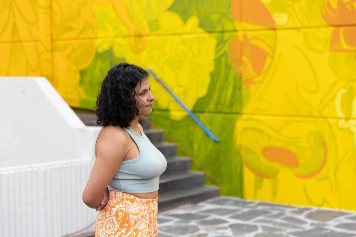 Colombian street artist and muralist Nathalia Gallego Sánchez, known in the art world as GLeo, speaks to a media source at the unveiling of her Adelante Juntos-Forward Together Duerksen Amphitheater mural on May 3.
