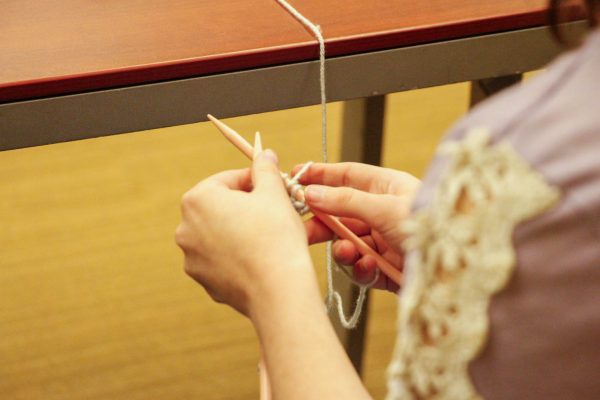 Paige Harrington begins creating a textile using knitting needles. Harrigton created the Threads Club to serve as a relaxing space for members of all skill levels.