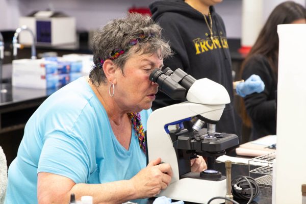 Using a microscope, Maria Martino focuses in on cells in a students dental swab. Martino teaches microbiology whenever the department has a need.