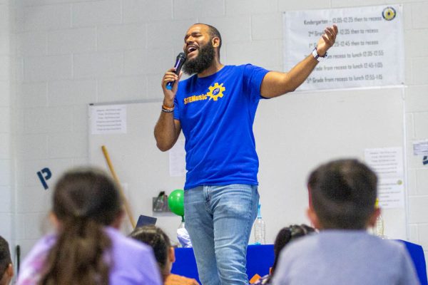 Roy Moye sings a song about engineering while performing a STEM-based show for students of Linwood Elementary. Moye led students through songs, activities and experiments to inspire them to pursue STEM-oriented careers.