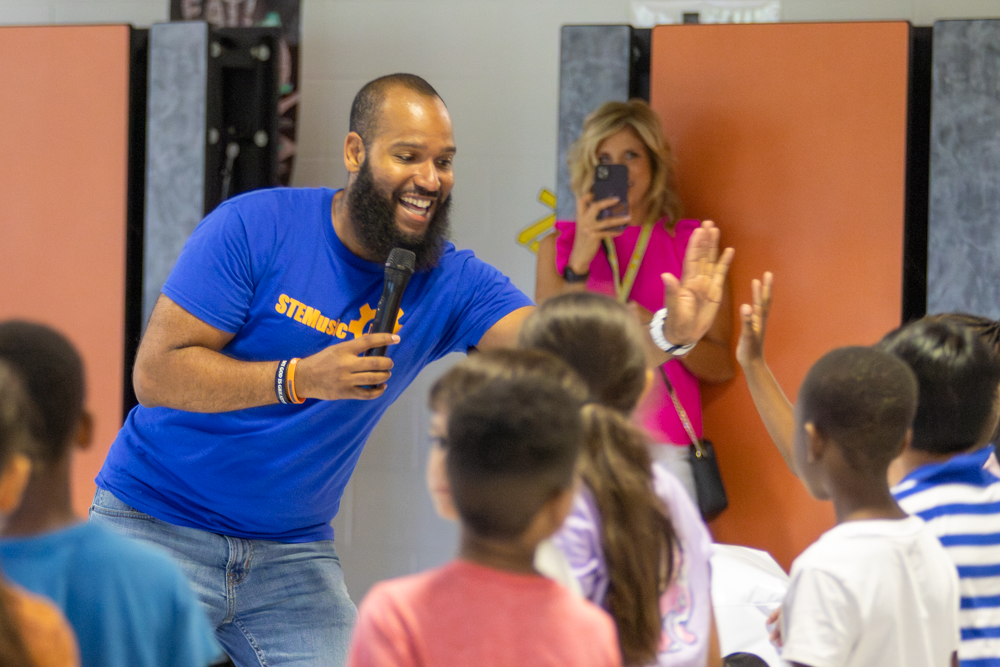 Roy Moye III highfives a student at Linwood Elementary for successfully answering a math problem during his show. Moye's show featured activities and experiments to help the kids explore STEM subjects and careers.