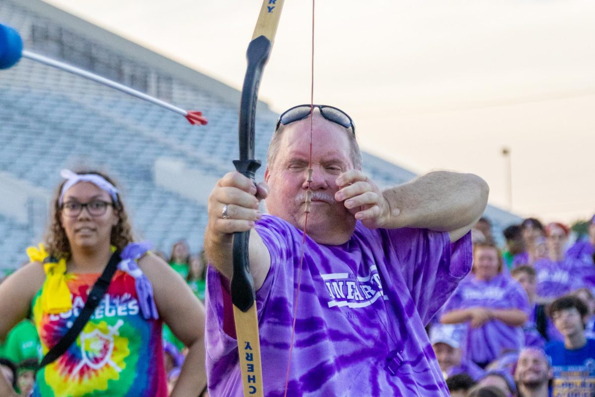 Fine Arts success coach Larry Compton plays archery against other college success coaches on Aug. 23 at Clash of the Colleges.