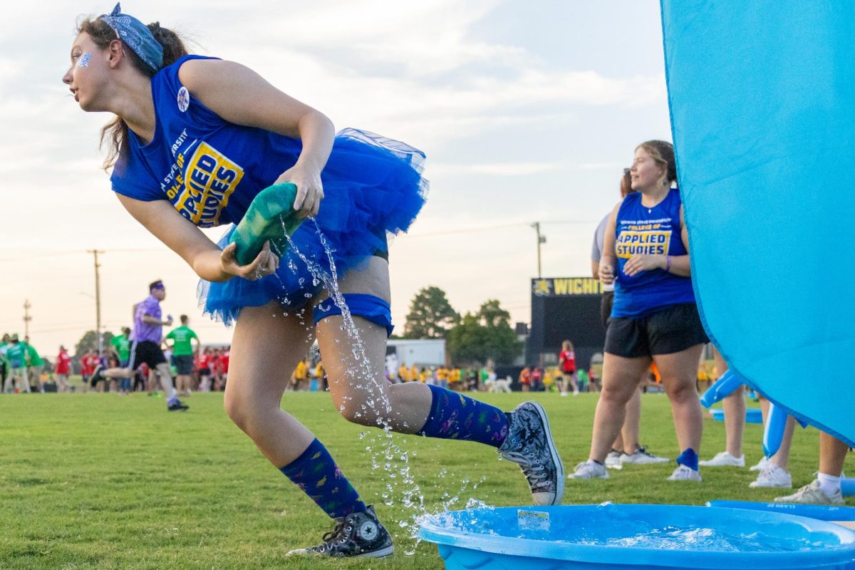 College of Applied Studies freshman Emma May carries a sponge full of water during the water sponge relay race at Clash of the Colleges on Aug. 23. May is a secondary education earth and space major.