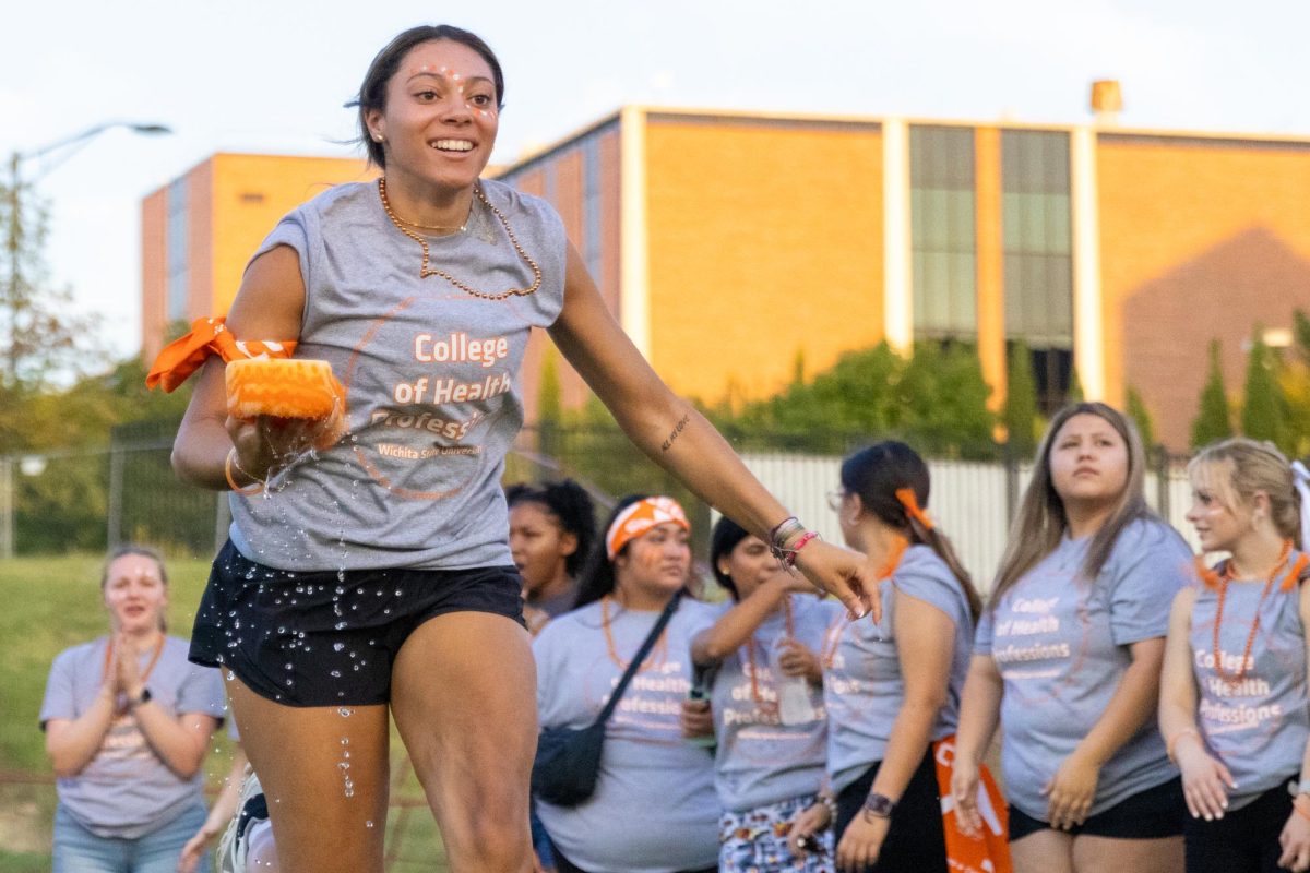 College of Health Professions freshman Ahmya Glover runs with a smile during the Clash of the Colleges water sponge relay race on Aug. 23. Glover is a pre-dental major.