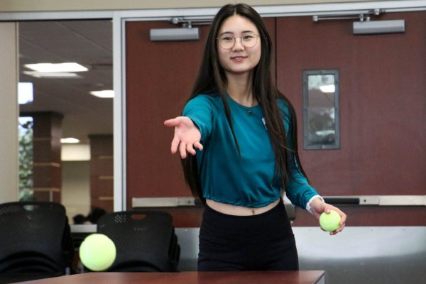 Rebecca Oh, a junior exercise science major, tries her hand at ADI's "Break the Pyramids of Stereotypes" game on Aug 27.