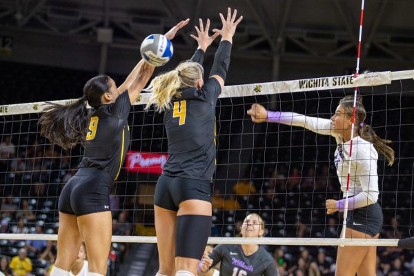 Fifth-year middle blocker Sarah Barham and junior outside hitter Brooklyn Leggett attempt a block against Kansas State on Aug. 24.