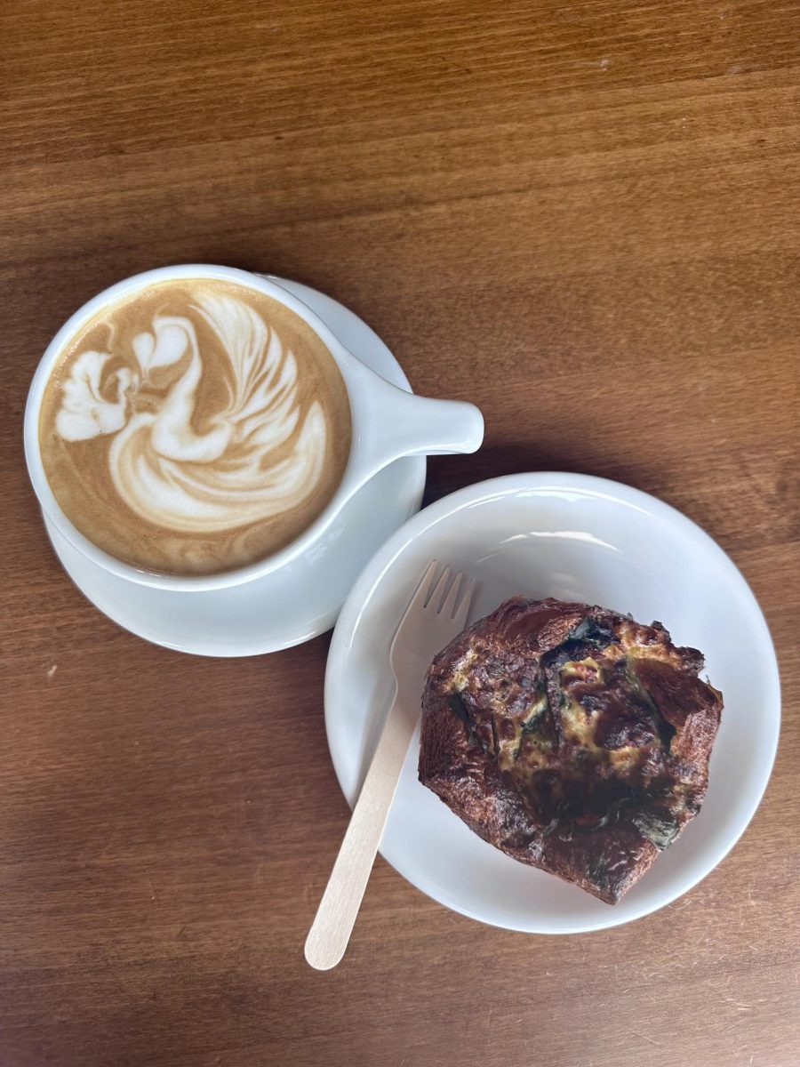 A coconut flavored latte and savory pastry from Reverie Coffee Roasters.  offers a wide variety of seating options along with a vast menu of coffee and baked goods. 