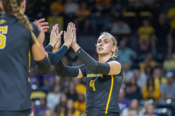 Junior Brooklyn Leggett high-fives teammates at the exhibition game against Kansas State. Leggett led the Shockers with 10 kills, 11 points and a .192 attacking percentage.