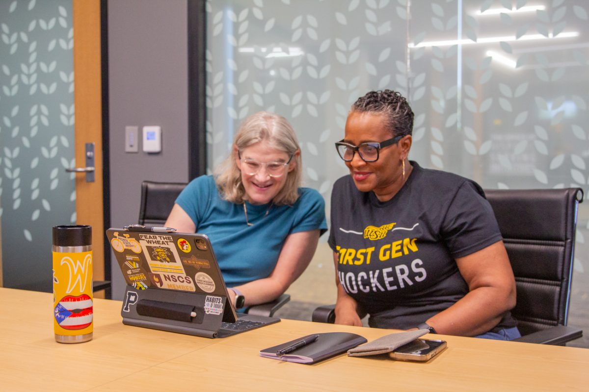 Pamela O'Neal, and Cynthia Pizzini sit in a conference room. O'Neal is  the associate director of Online and Adult Learning and Pizzini is an adult learner who mentors her peers.