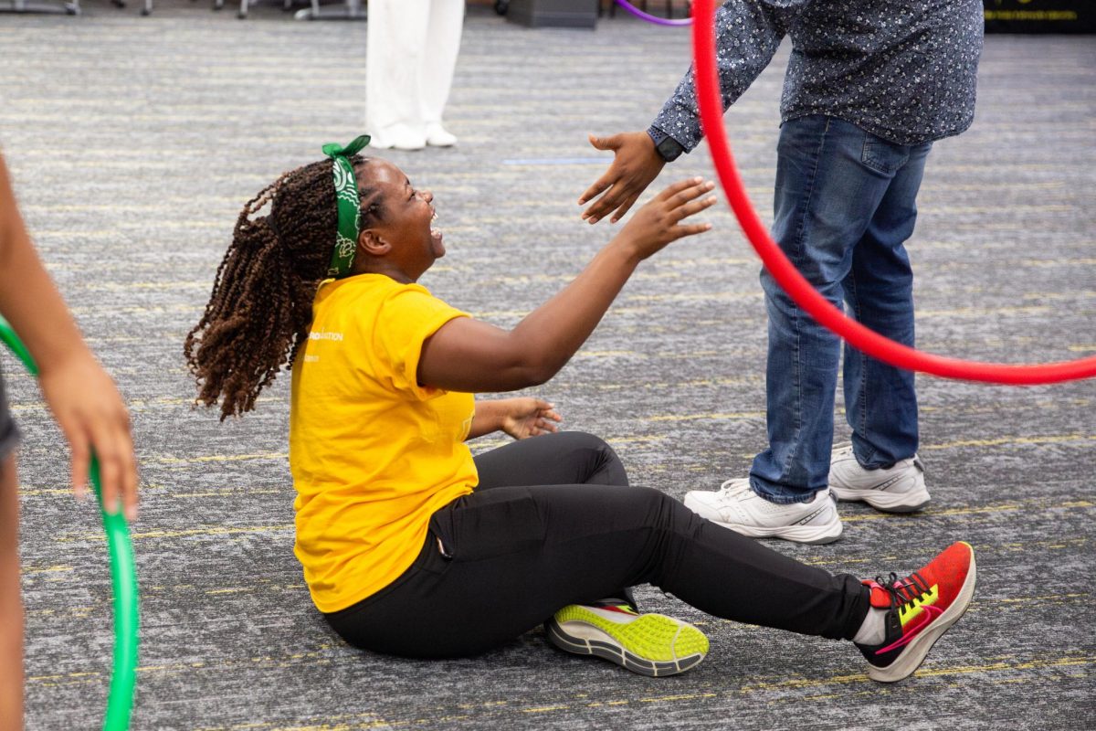 Leonidah Chepkoech falls on the floor laughing after watching one of her teammates get hit with a pool noodle below the stomach.