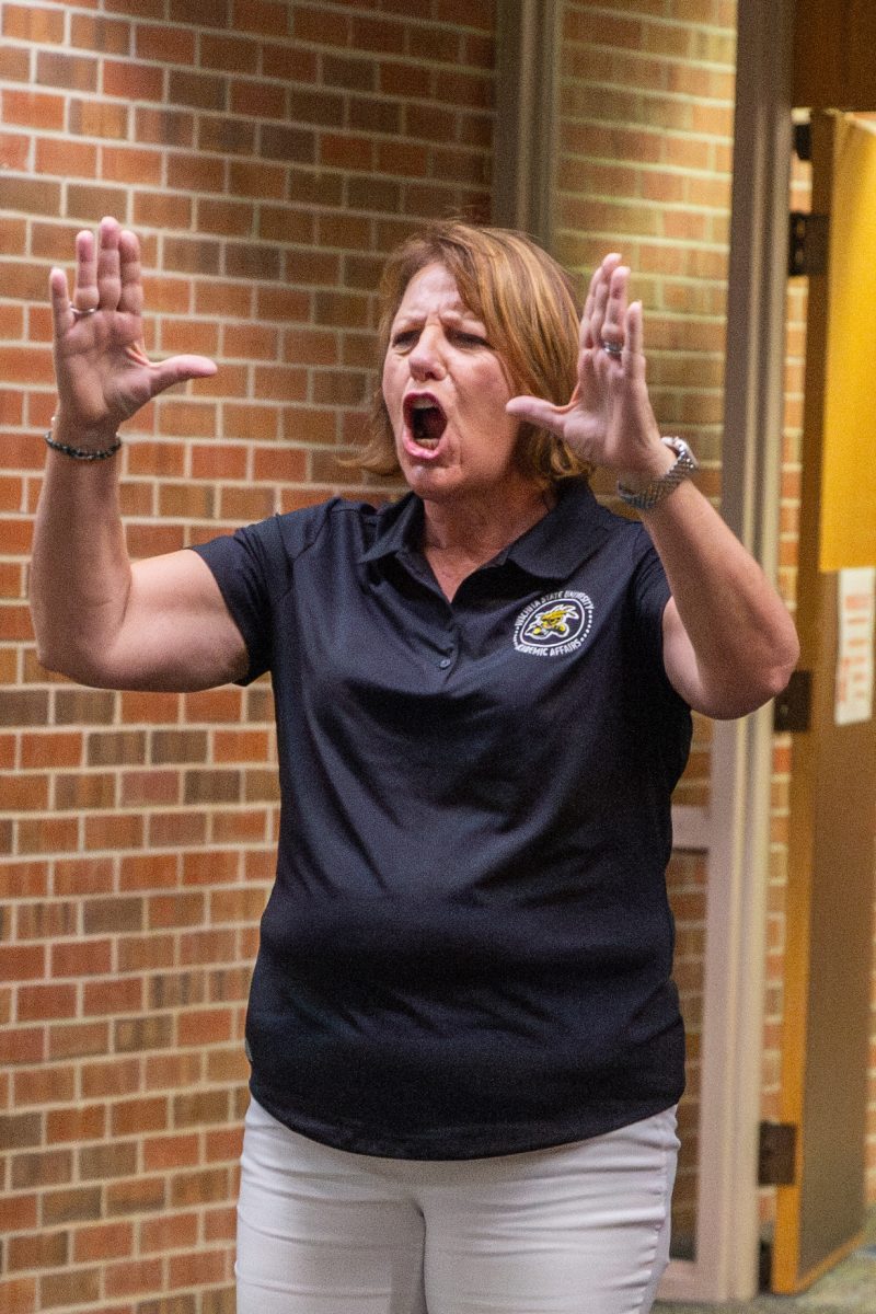 Provost Shirley Lefever cheers after her team makes it to the end of the poly spot relay race. Faculty and staff gathered in Ablah Library on Aug. 2 to compete in a makeshift Olympics.