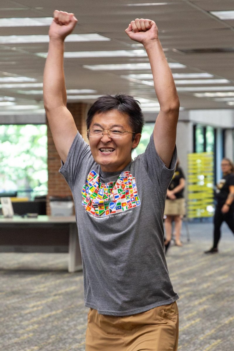 Jian Wang, assistant chemistry professor at WSU, cheers after knocking down a set of bowling pins during the practice round.