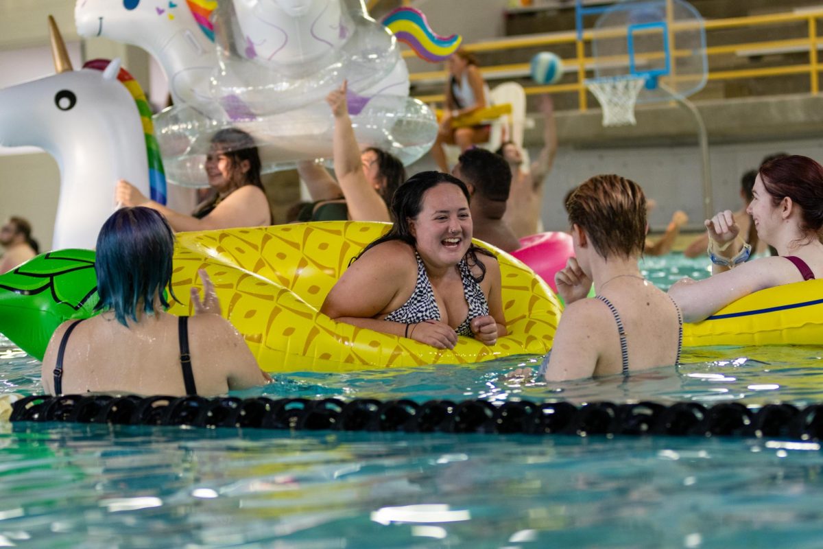 Junior psychology major Hailey Raver smiles at her friends in the pool of the Heskett Center on Aug. 15 for the annual pool party.