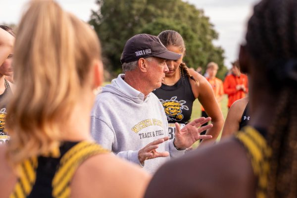 Head coach Kirk Hunter speaks to the women's cross country team before the start of the JK Gold Classic race. Wichita State took third overall, with two individuals in the top 15.