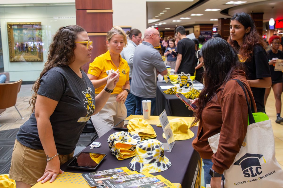 A Shocker Career Accelerator representative discusses their online help guide with a student. 