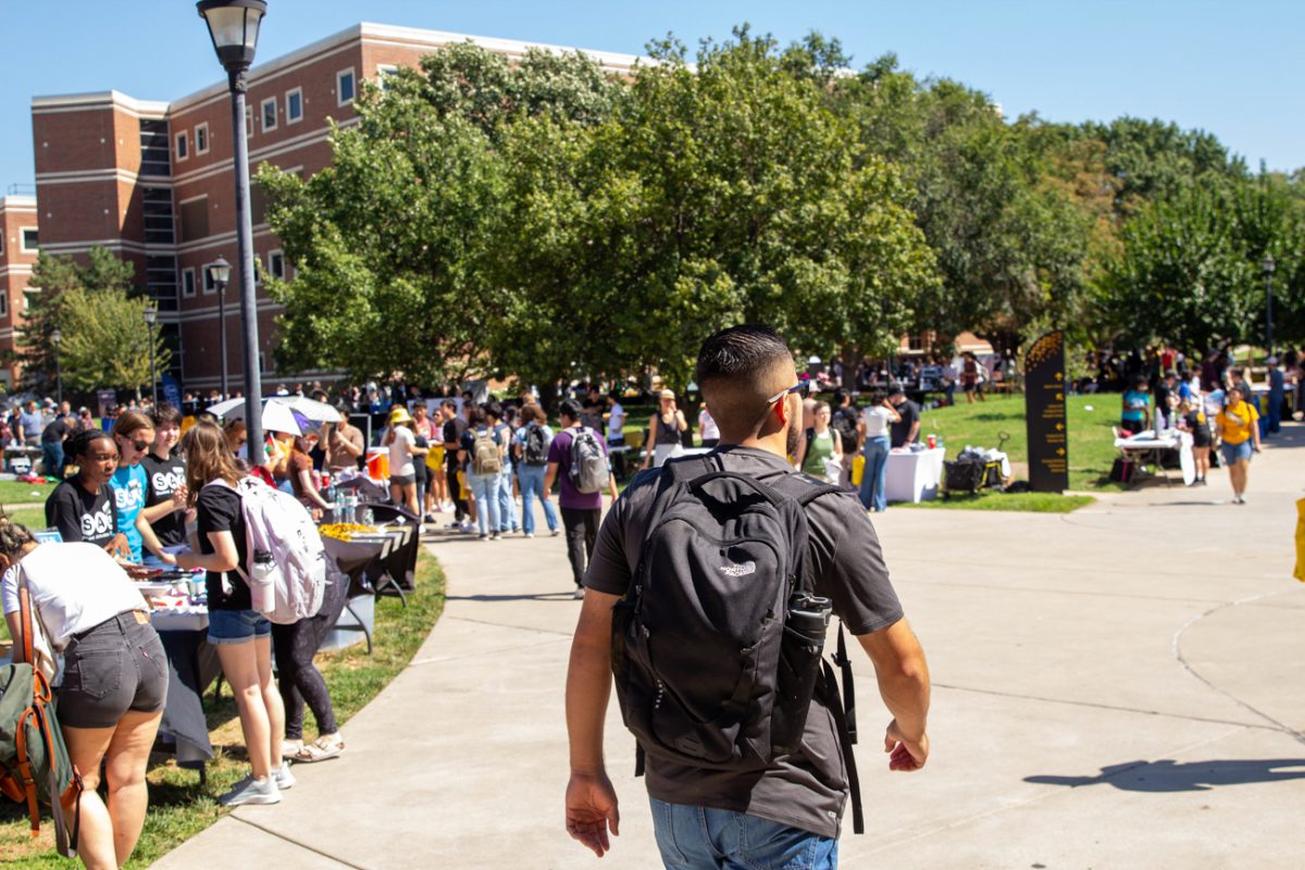 Man walks through the Community & Involvement Fair. 