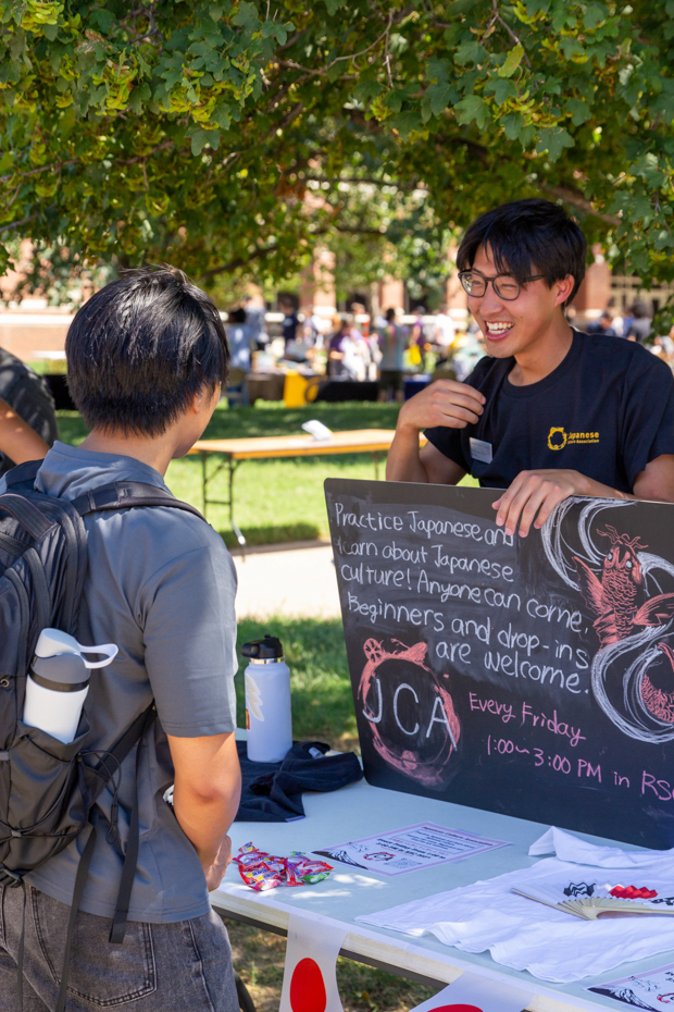 A member of the Japanese culture association encourages an interested student to join the group. 