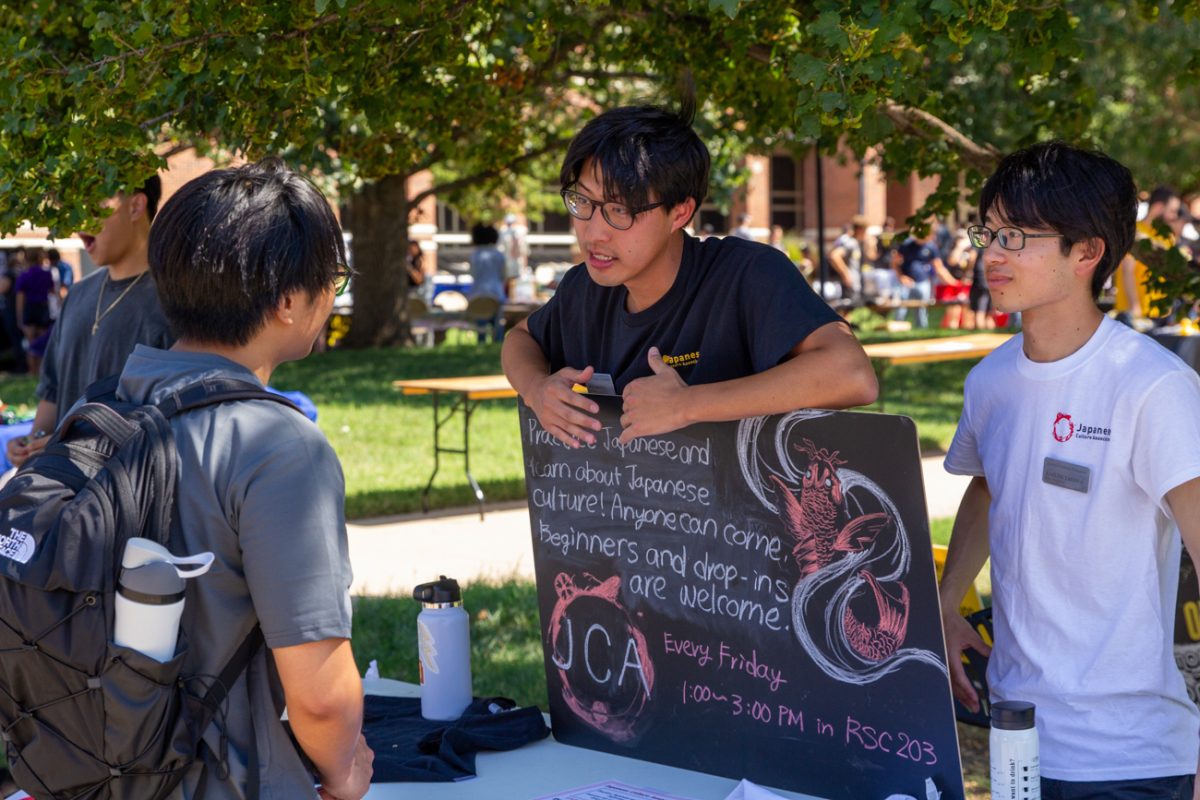 A member of the Japanese Culture Association encourages an interested student to join the group. 