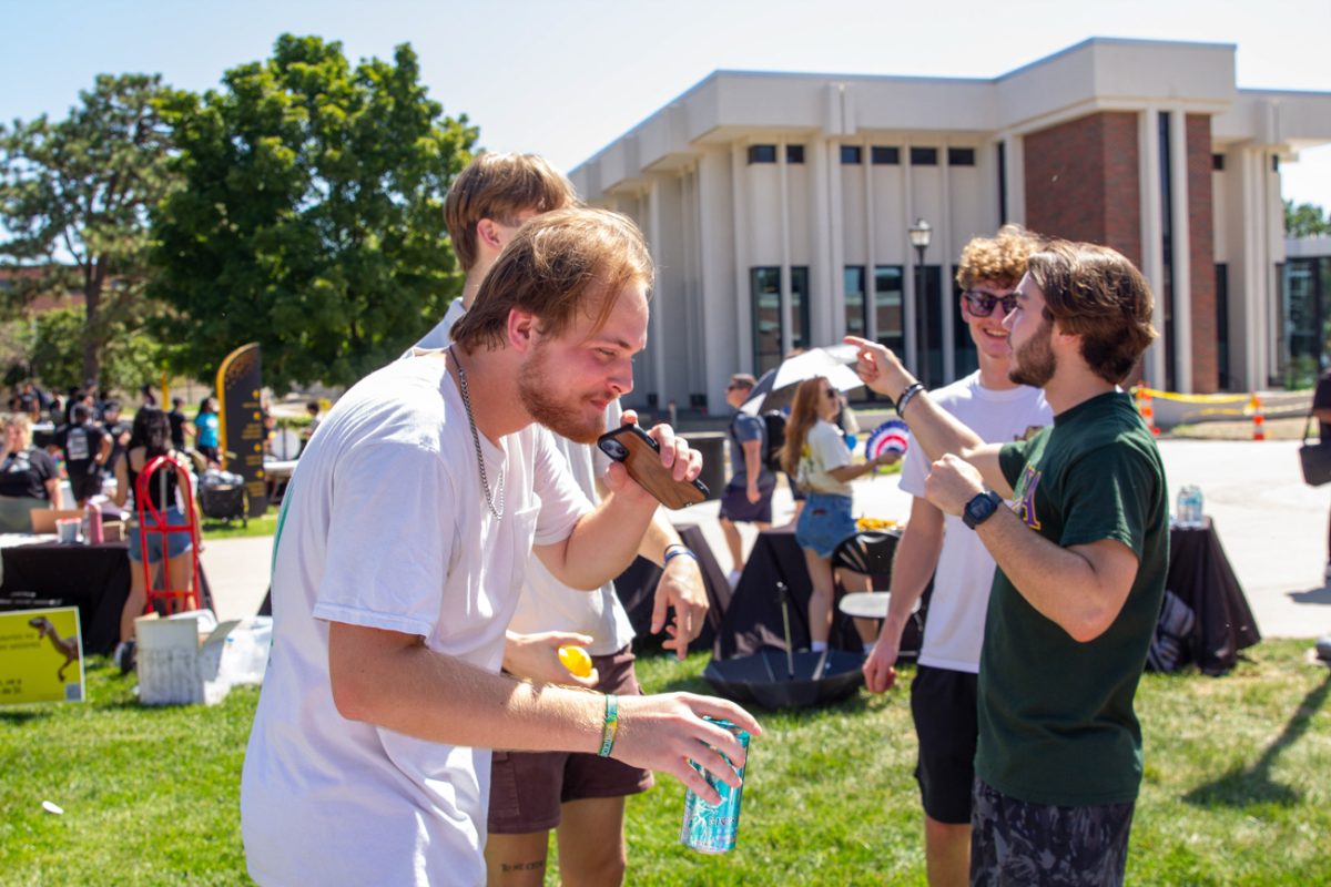 Student Mason Salmond from Lambda Chi Alpha cracks open a drink. Many refreshments were available for students to combat the heat.