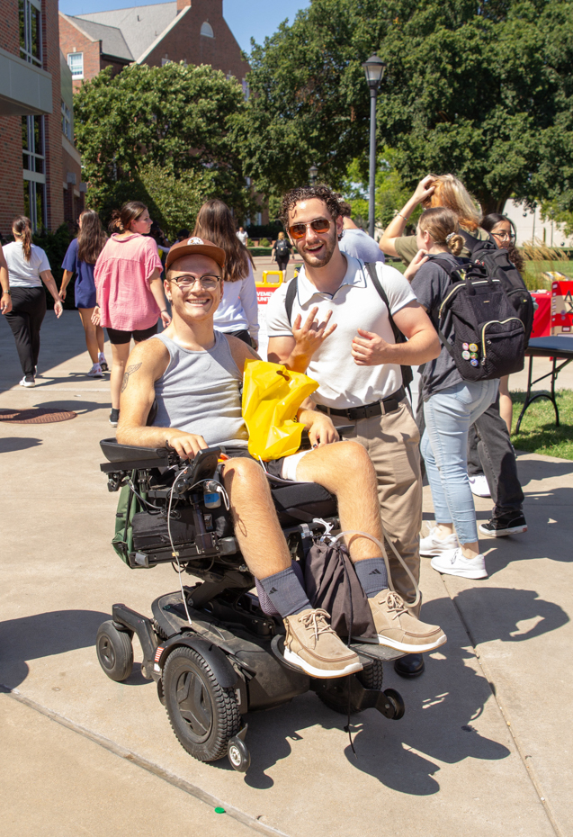 student layton maienschein and his friend pose for a picture as they are about to enter the inside section of the involvment fair.