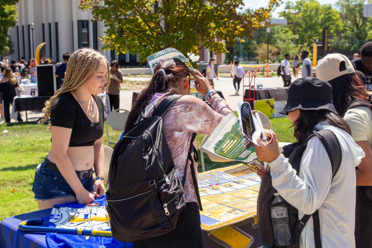 student arianna sallaz talks to students interested in sigma gamma rho. to arianna, this was a chance to represent her soririty as a newly pledged member..