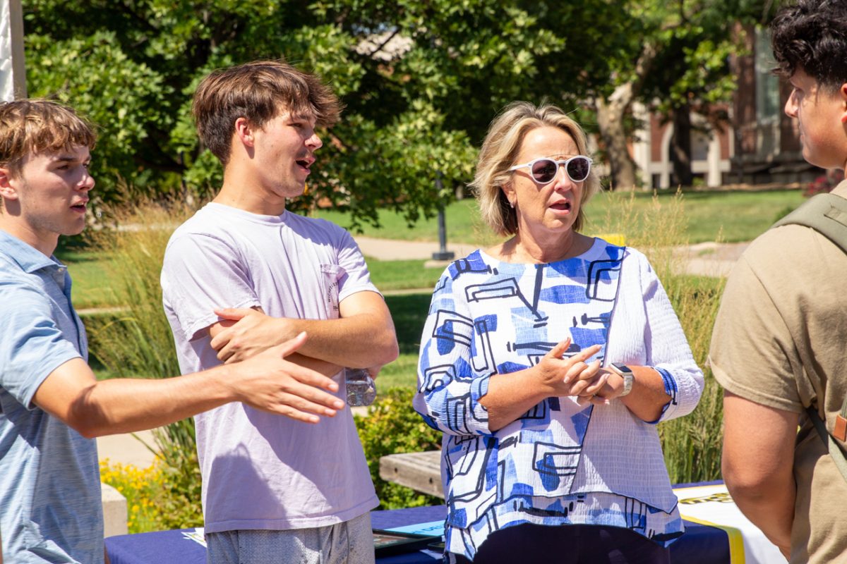 Andrew Lathem and Vice President for Student Affairs Teri Hall speak about Lathem's fraternity at the student involvement fair. 