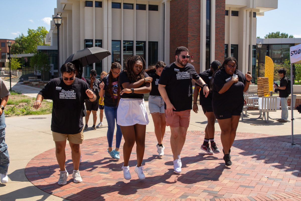 Staff from the Office of Student Engagement and Belonging dance along to the Cha-Cha Slide. A handful of students joined in.