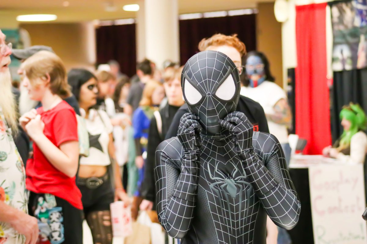 A Spiderman cosplayer adjusted their mask for better vision. Many characters were present at the ICT Comic-Con, with Spiderman being one of the most prominent. 