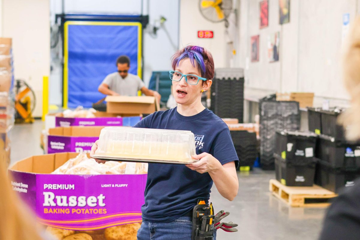 Jillian Ohmarts, a Kansas Food Bank volunteer coordinator, tells the volunteers where to place baked goods. Ohmarts explained how their sorting sytem has helped them get everything to the right place.