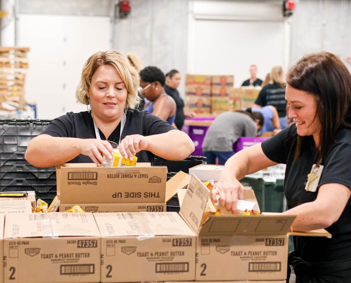 Peggy Hackett, a manager for Azria Health, helps sort out cookies with her coworker. "I saw the opportunity to help. Everyone was on board. It's our way of giving back," Hackett said. The group chose volunteering as their company's monthly staff celebration.