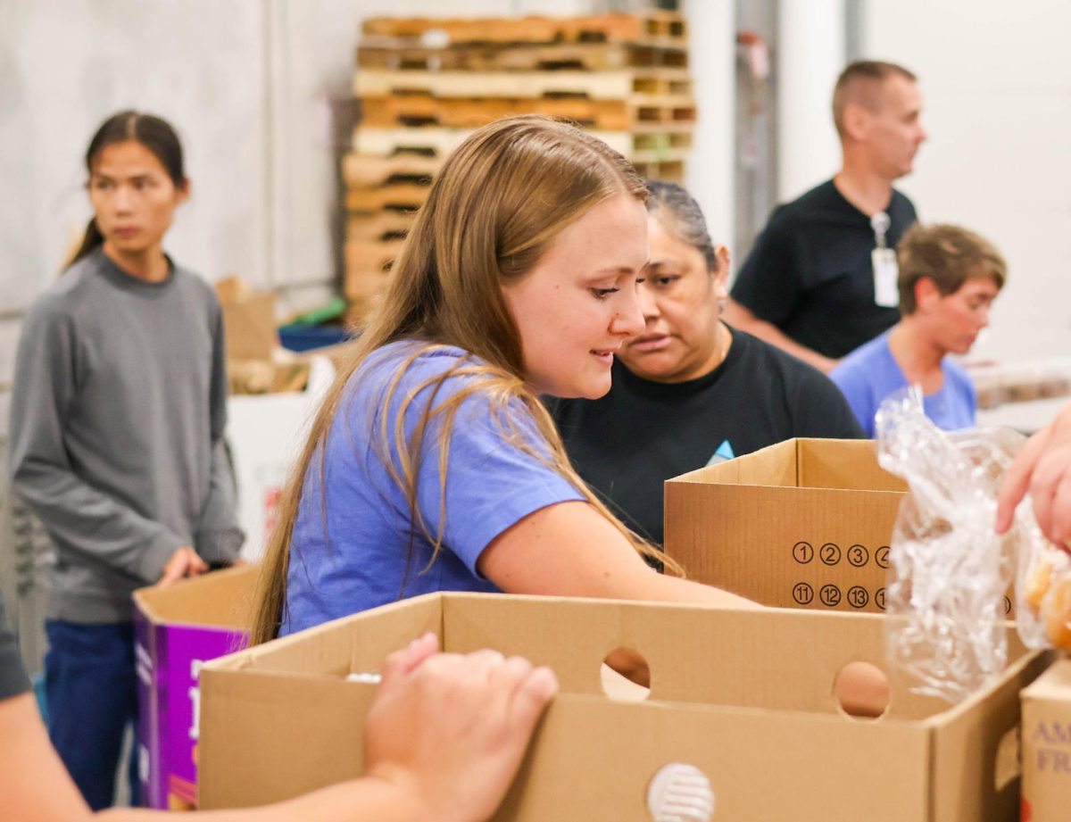 An Azria Health staff member aids her coworkers by sorting out bread into the baked good bins. The group designated each person with a job so that everything could go smoothly.