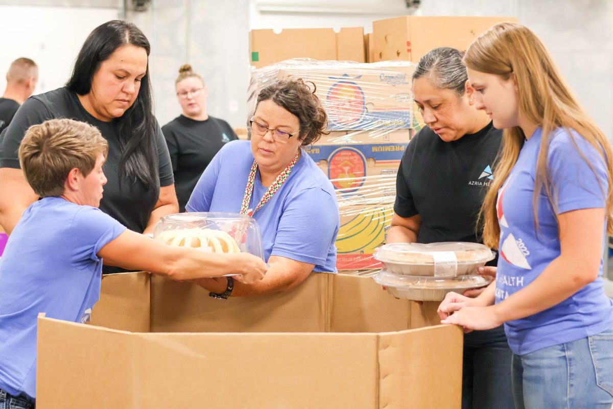 Azria Health staff members work together to help sort out cakes and pies into the baked good bins. The group decided to get as many hands on deck as possible so that they could start on their next assignment earlier than expected.