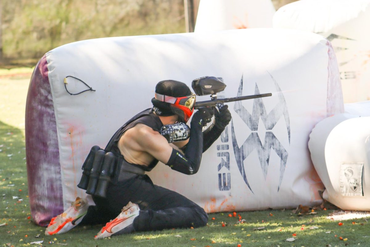 Senior Cody Griffin takes cover while attempting to eliminate an enemy team member. The Wichita State University paintball club began accepting members last semester.