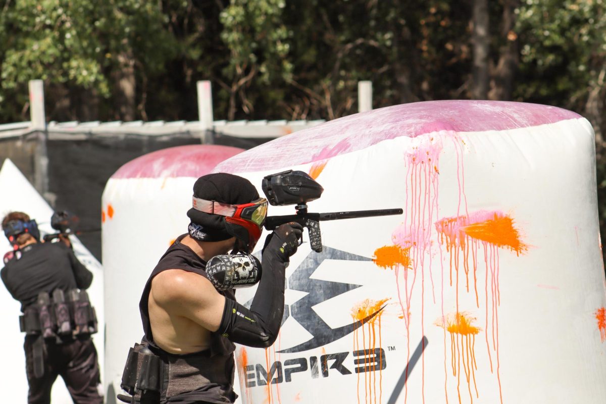 Senior Cody Griffin hides behind the barricade while aiming at an opponent. The Wichita State paintball club has competed against teams such as Texas A&M and Texas Tech.