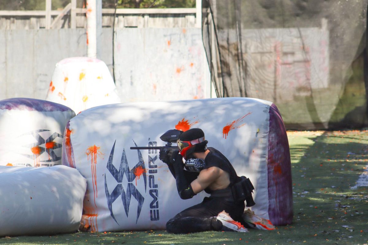 Senior Cody Griffin kneels, aiming to take out the enemy. The paintball club hopes to make a bigger presence on campus, welcoming everyone who wants to join and have fun in the upcoming year.