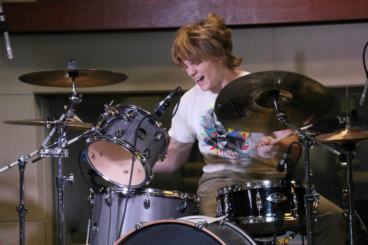 Jack Anderson, Petals band member, and English graduate teaching assistant plays drums at Mini Music Fest in the Rhatigan Student Center on Sept. 20. Alongside live music, the event included a variety of vendors from local businesses.