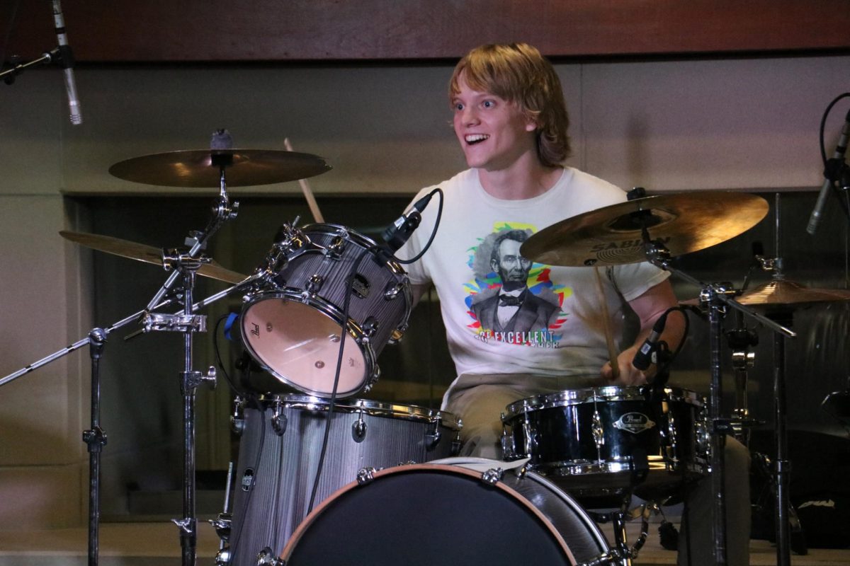 Jack Anderson, Petals band member, and English graduate teaching assistant plays drums at Mini Music Fest in the Rhatigan Student Center on Sept. 20. Alongside live music, the event included a variety of vendors from local businesses.