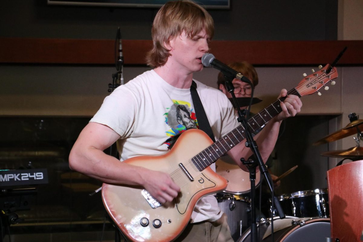 Jack Anderson, Petals band member, and English graduate teaching assistant performs at Mini Music Fest in the Rhatigan Student Center on Sept 20. Alongside live music, the event included a variety of vendors from local businesses.