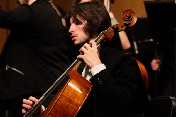 Spenser Nash, a WSU student and cellist, tunes before the orchestra's performance of "The Block".