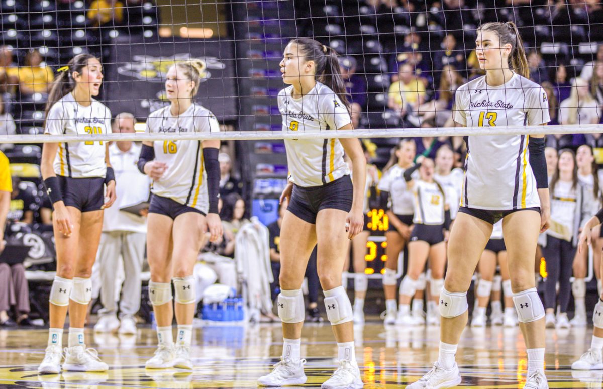 Redshirt freshman Alyssa Gonzales and fifth-year Izzi Strand talk between points, while fifth-year Sarah Barham and junior Emerson Wilford prepare for a serve against Cal Poly. Wichita State won on Thursday night in comeback fashion, 3-2.
