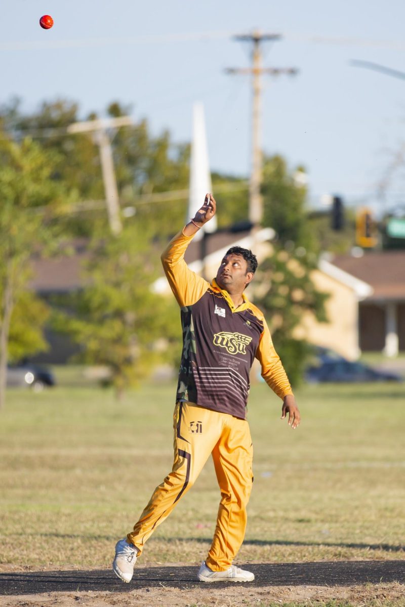 Cricket Club President Sai Karthik Garnepudi catches the ball after it goes out of play during practice. The Wichita State Cricket Club practices in Dr. Glen Dey Park on Fridays.