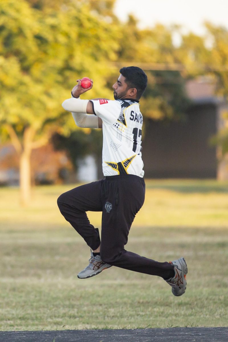 Samarth Joshi jumps into the air before bowling his ball toward the batter at Cricket Club practice. The team meets weekly.