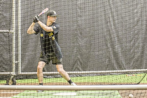 Baseball club president Collin Dugan takes front toss batting practice towards the end of the club's meeting on Aug. 26.