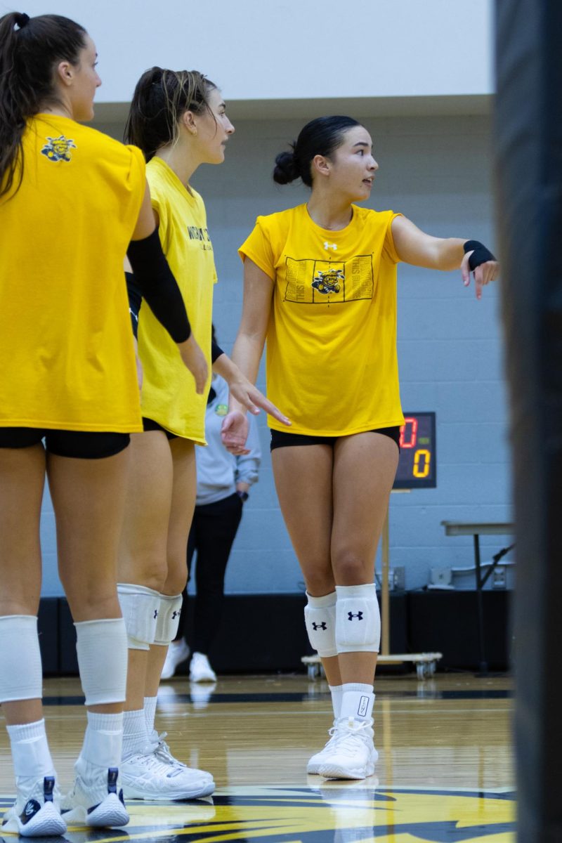 Freshman Nadia Wasilewski, junior Emerson Wilford and fifth year Sarah Barham watch and point that the ball is in during a practice on Aug. 15 in Charles Koch Arena.