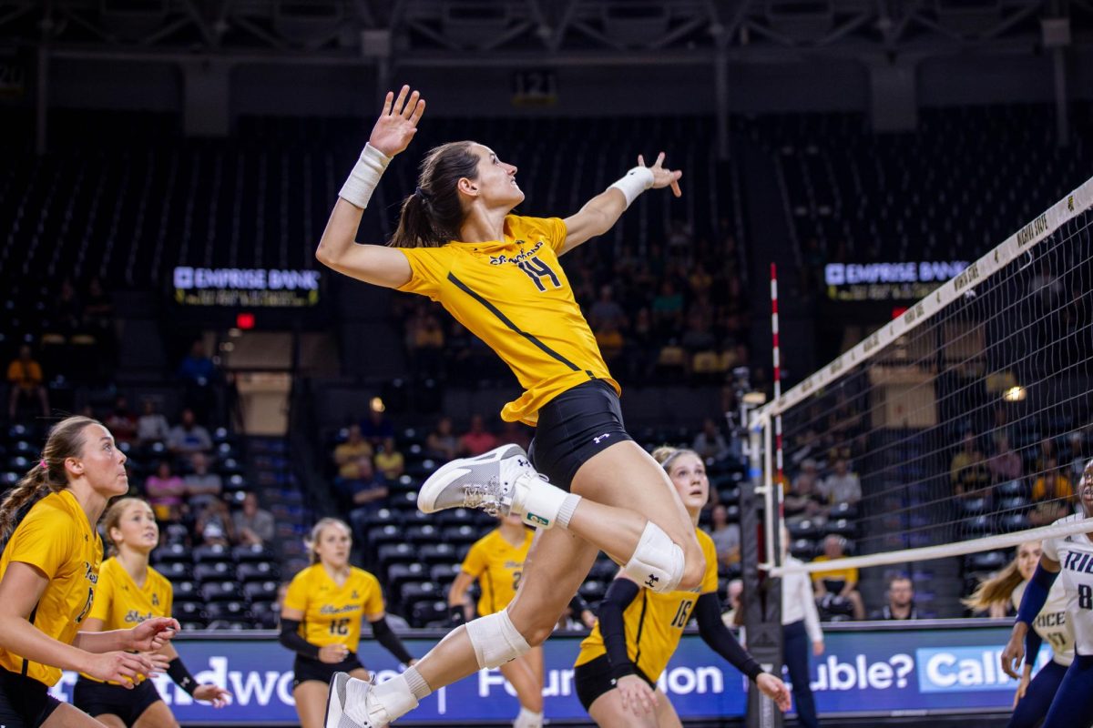 Maddie Wilson jumps to hit the ball over the net in the second set. Wilson had nine kills during the game against Rice on Oct. 6.