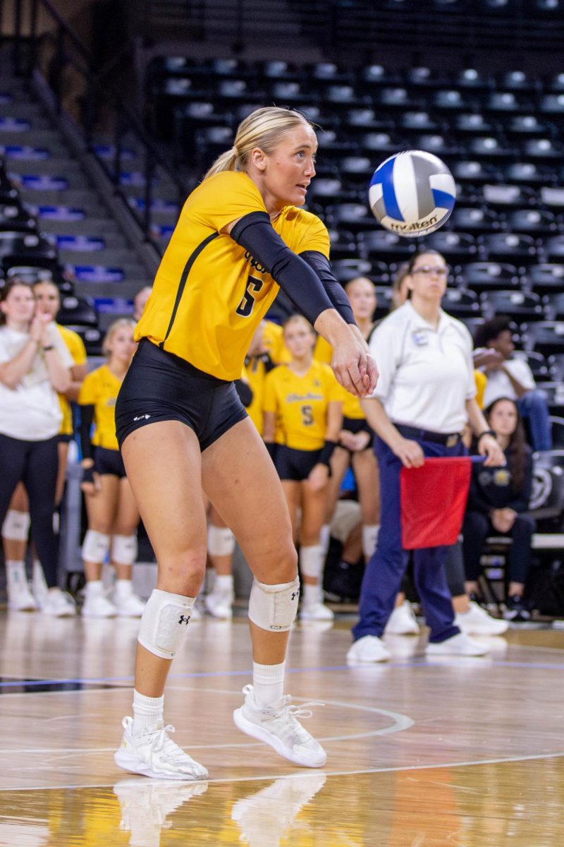 Katie Galligan passes the ball to a teammate in the fourth set. Galligan, a junior, scored 11 digs during the game on Oct. 6.