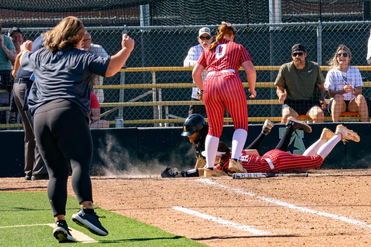 Sophomore Sydney Zenon slides into home plate just behind the ball, resulting in an out. Wichita State softball played against Southern Nazarene University, finishing with a dominant score of 18-1.