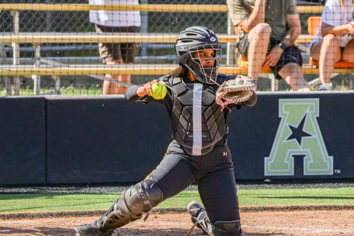 Freshman Gabby Scott throws the ball back to the pitcher on Oct. 5. Scott has experience as both a catcher and outfielder in high school.